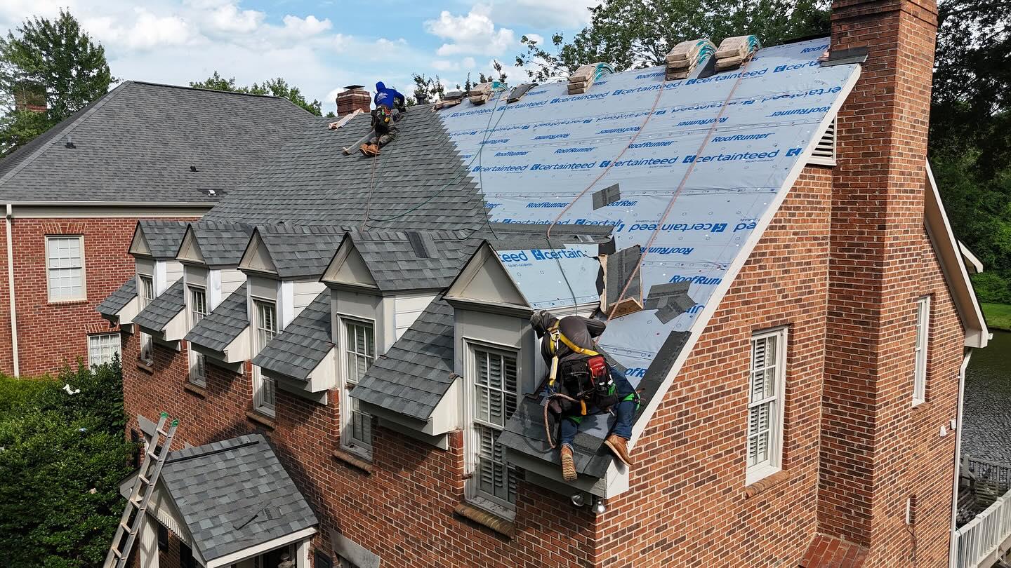 Roofing crew working on brick estate Nassau County